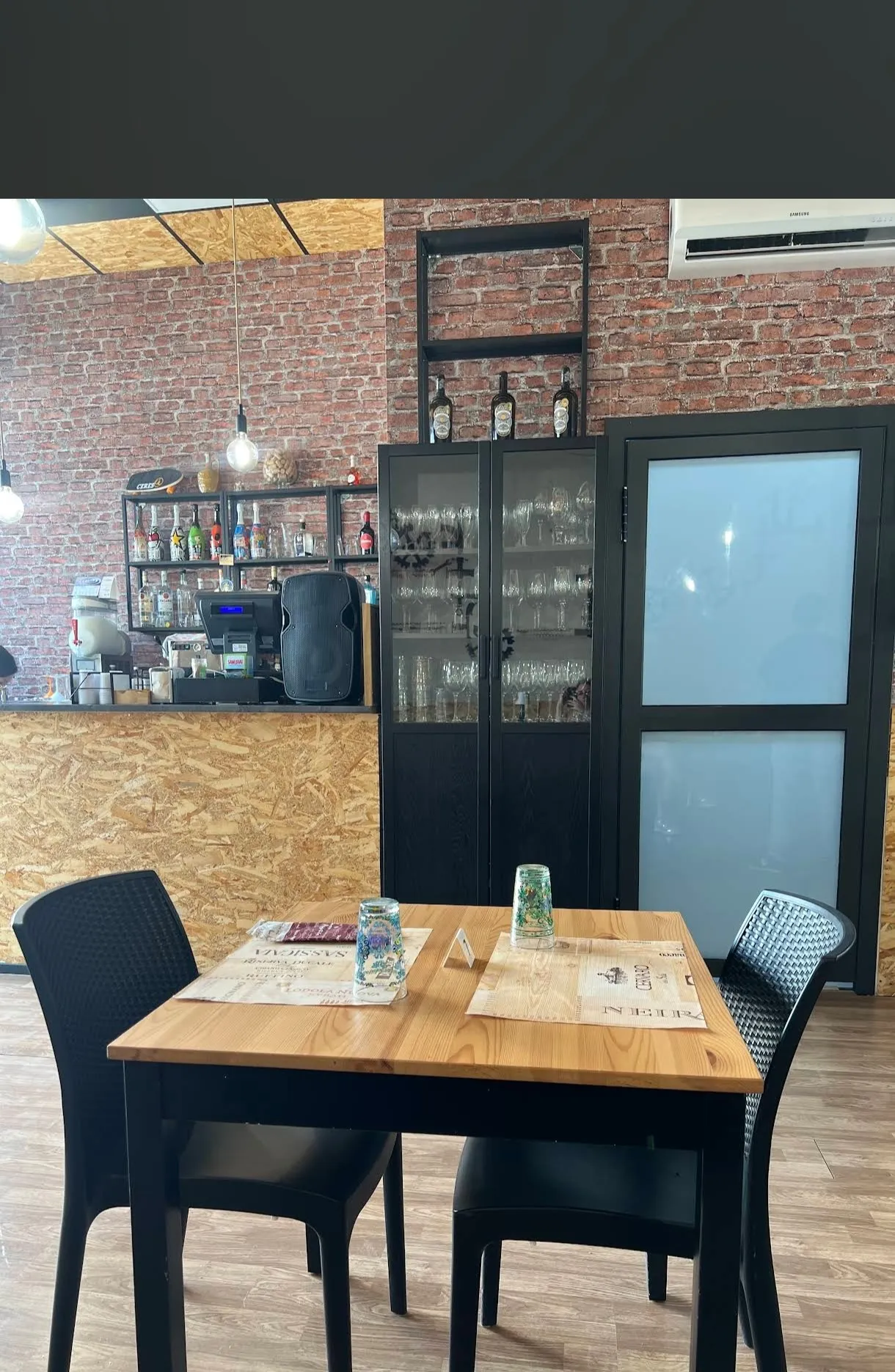 Sala interna con bancone bar e parete in mattoni a vista
